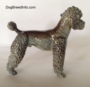 The right side of a figurine of a black, gray and brown Poodle. The body of the poodle is average length.