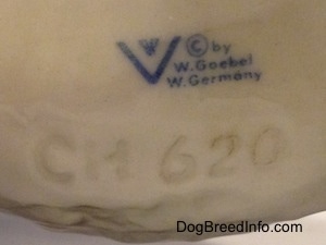 Close up - The underside of a Poodle figurine has the logo of Goebel W. Germany stamped on and under that is an engraving the reads 'CH620'.