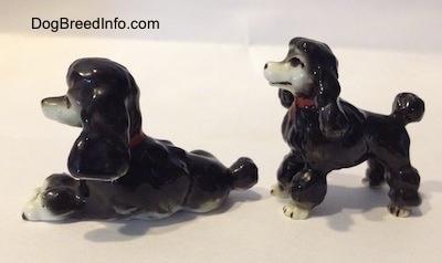Two little black and white ceramic poodles