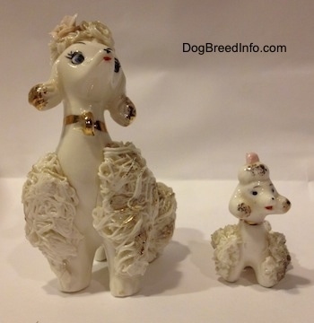 Two white Spaghetti porcelain figurines of Poodles. The figurines have there mouths painted open.