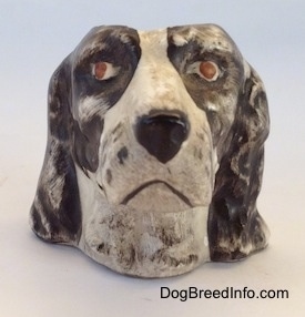 A brown and white Russian Spaniel dog stein cup. The figurine has red eyes.
