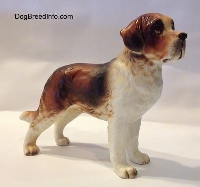 The front right side of a figurine of a Saint Bernard. The figurine has long legs.