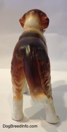 The back of a brown and white Saint Bernard figurine. The figurines tail is hard to differentiate from its back side.