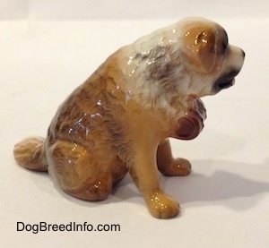 The right of a brown with white Saint Bernard figurine in a sitting position. It is hard to differentiate the ears of the figurine from its head.