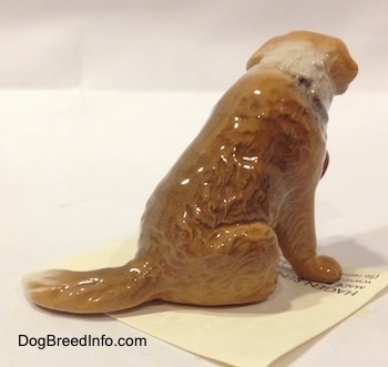 The back right side of a brown with white figurine of a Saint Bernard. The figurine has fine hair details.