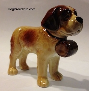 The front right side of a porcelain Saint Bernard figurine. The figurine is glossy.
