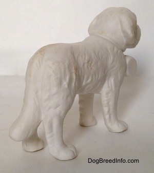 The back right side of a white bisque porcelain Saint Bernard figurine. From this angle it is hard to differentiate the ears of the figurine from its head.