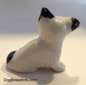 The right side of a white with black Schnauzer figurine. The figurine has short legs.