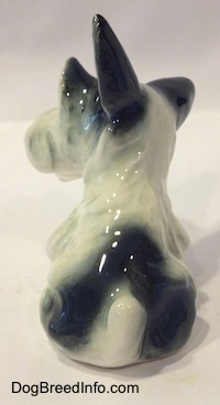 Back view of a ceramic dog figurine with large black ears