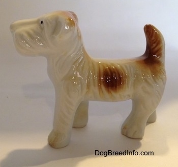 The left side of a bone china white with brown bone china Schnauzer figurine. The ears of the figurine are hard to differentiate from its head.