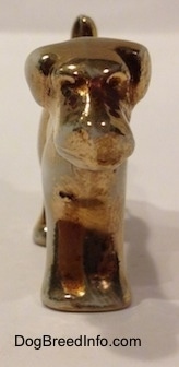 A bone china Schnauzer figurine that is painted gold.