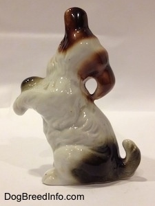 The left side of a bone china Miniature Schnauzer in a begging pose figurine. The right ear of the figurine is attached to the back.