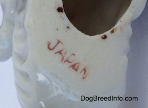 Close up - The underside of a bone china Schnauzer figurine. There is the red stamp of Japan on the underside.