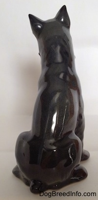 The back of a grey figurine of a Schnauzer. The figurine has a short tail.