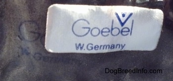 Close up - The underside of a figurine of a Scottish Terrier. There is a sticker on the underside that reads 'Goebel W.Germany'.