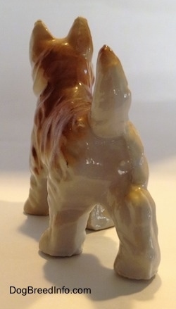 The back of a bone china brown and white Scottish Terrier figurines. The tail of the figurine is arched in the air.