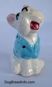A ceramic Scottish Terrier figurine in a blue with black short and it is in a sitting position. The figurines head is tilted to the left and its mouth is painted open.