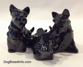A black Scottish Terrier figurine trio. The figurines are not painted.
