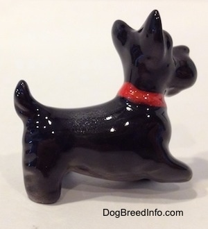 The right side of a figurine of a black Scottish Terrier. The figurines body is longer than its legs.