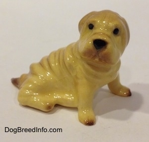The right side of a Chinese Shar-Pei figurine. The figurine has black circles for eyes.