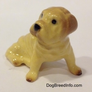The front right side of a figurine of a Chinese Shar-Pei. The ears of the figurine are brown.
