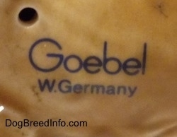 Close up - The underside of a figurine of a German Shepherd puppy. It has the stamp of Goebel W.Germany on it.