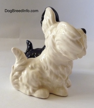 The right side of a figurine two of Skye Terriers sitting. The figurines have fine hair details.