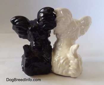 The back of a figurine of two sitting Skye Terriers. The figurines are glossy.