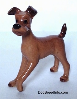 A brown with black figurine of a dog that looks like 'Tramp' from 
   Disneys The Lady and The Trump'.