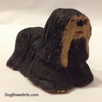 A black with tan Tibetan Terrier figurine. The figurine has a full coat of hair.