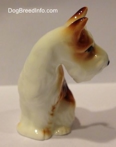 The front left side of a white and brown figurine of a bone chine Wire Fox Terrier. The figurine is looking to the right.