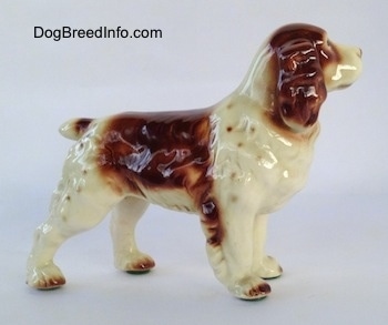 The right side of a white and brown figurine of a Welsh Springer Spaniel. The figurine is glossy.