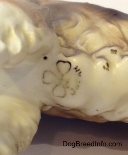 The underside of a porcelain Welsh Springer Spaniel figurine that has a clover hallmark on the bottom.