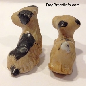 The back right side of two figurine of miniature Welsh Terrier puppies. The figurines had black ears.