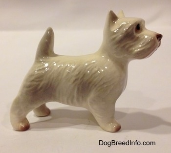 The right side of a figurine of a white with tan West Highland Terrier. The figurine has fine hair details along its body.