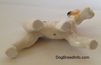 The underside of a bone china Wire Fox Terrier figurine. The figurine has a small hole on the underside.