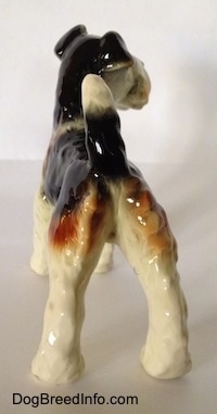 The back of a figurine of a black and white with brown Wire Fox Terrier. The figurine has fine hair details.