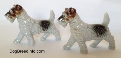The left side of two figurines of white with black and brown Wire Fox Terriers. The figurines have brown ears.