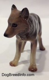 A figurine of a brown with tan Wolf. The figurine has a detailed face.