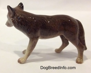 The left side of a figurine of a brown with tan Wolf. The figurine has fine hair details along its body.