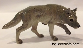 The right side of a stalking gray Wolf figurine. The figurine is glossy.